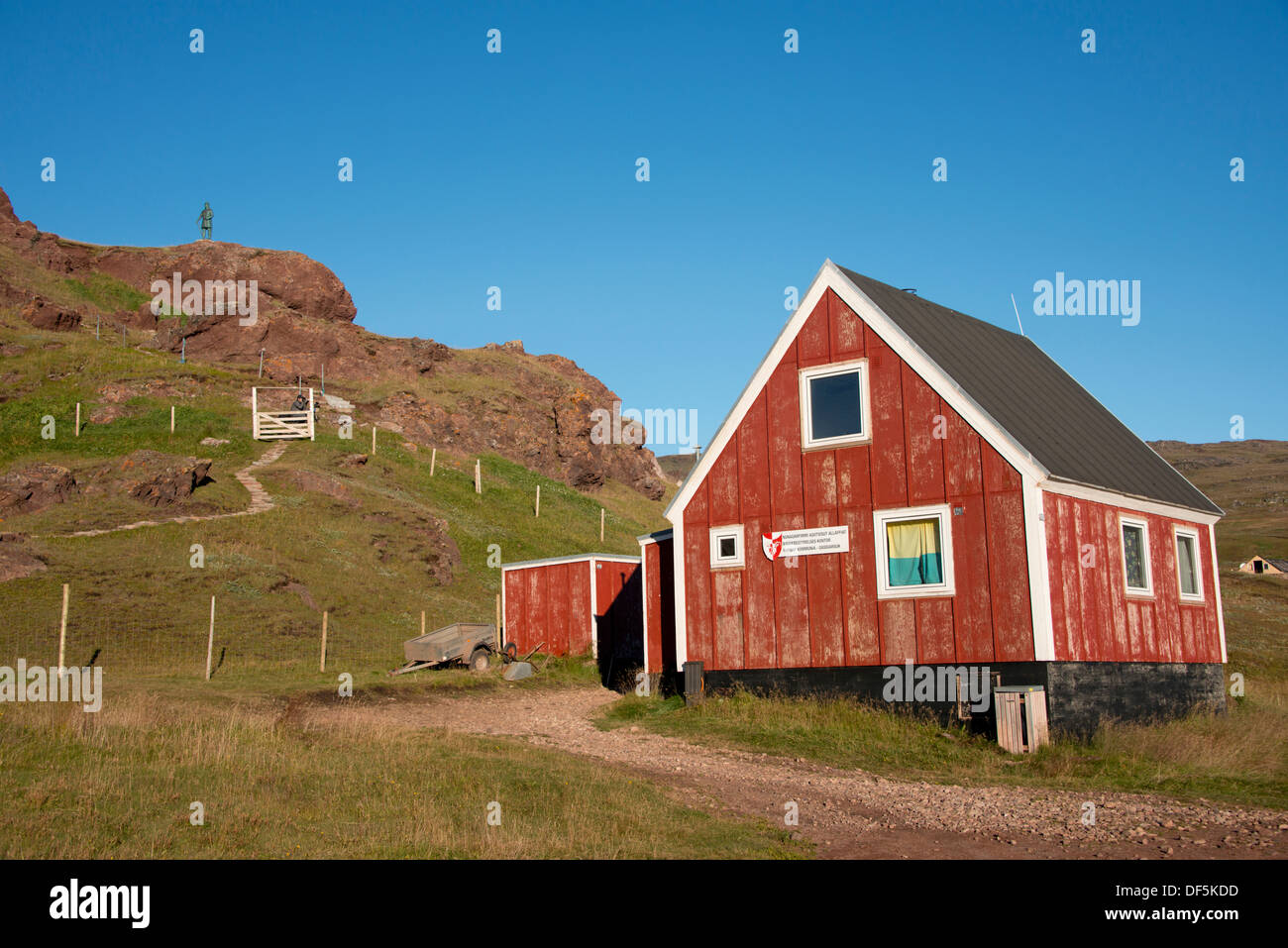 Le Groenland, (alias Tunulliarfik Erik's Fjord), Qassiarsuk, Brattahlid, Erik le Rouge est de l'établissement. Red cottage avec Viking statue dans la distance. Banque D'Images