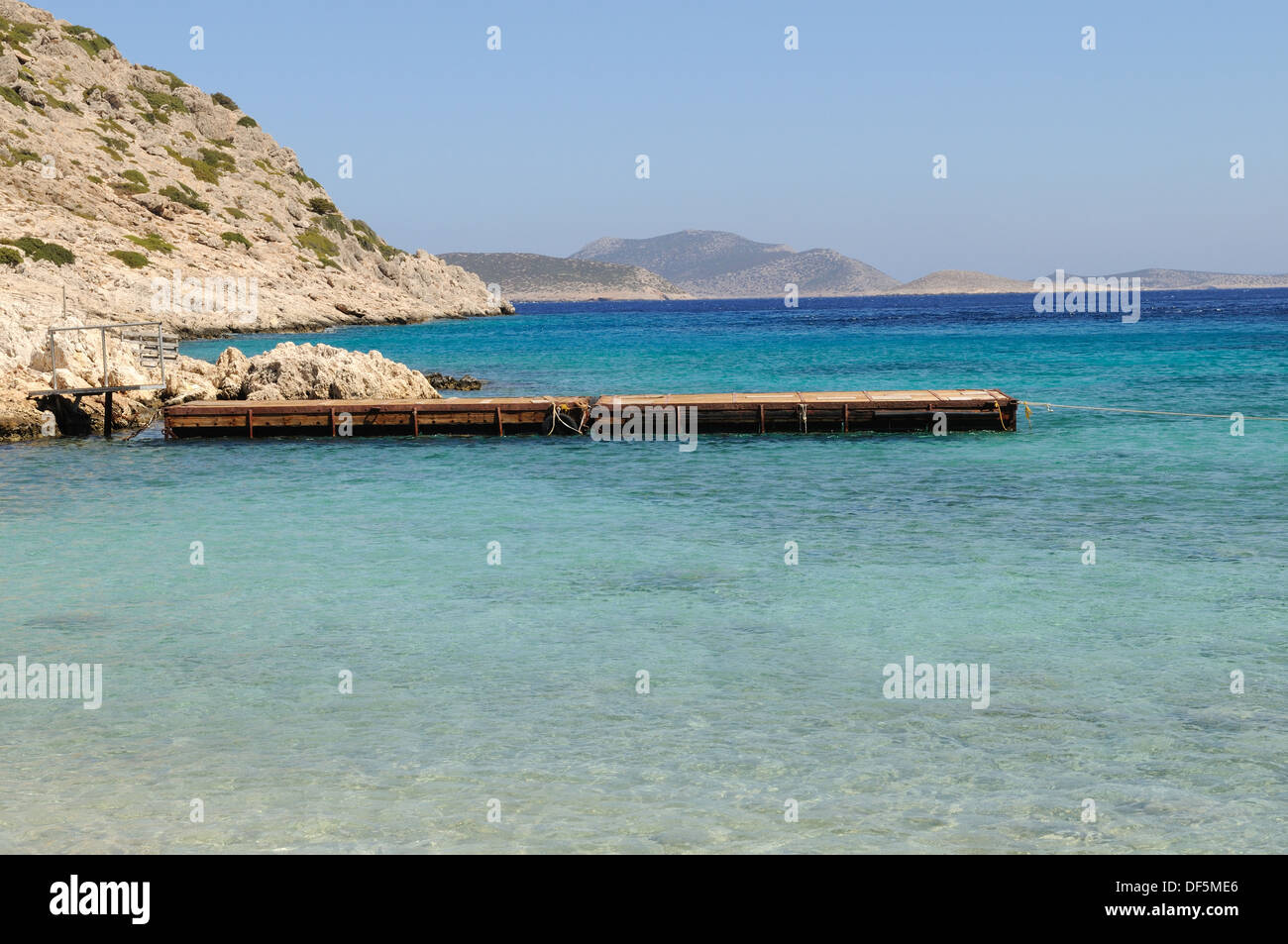 Jetée en bois dans une mer bleu clair Kania Halki Chalki Plage île grecque du Dodécanèse Mer Égée Grèce Europe Banque D'Images