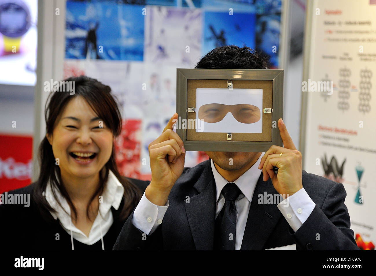 Homme sourit à travers la vision masque au salon Nanotech Japon tandis que les femmes collègue rit Banque D'Images