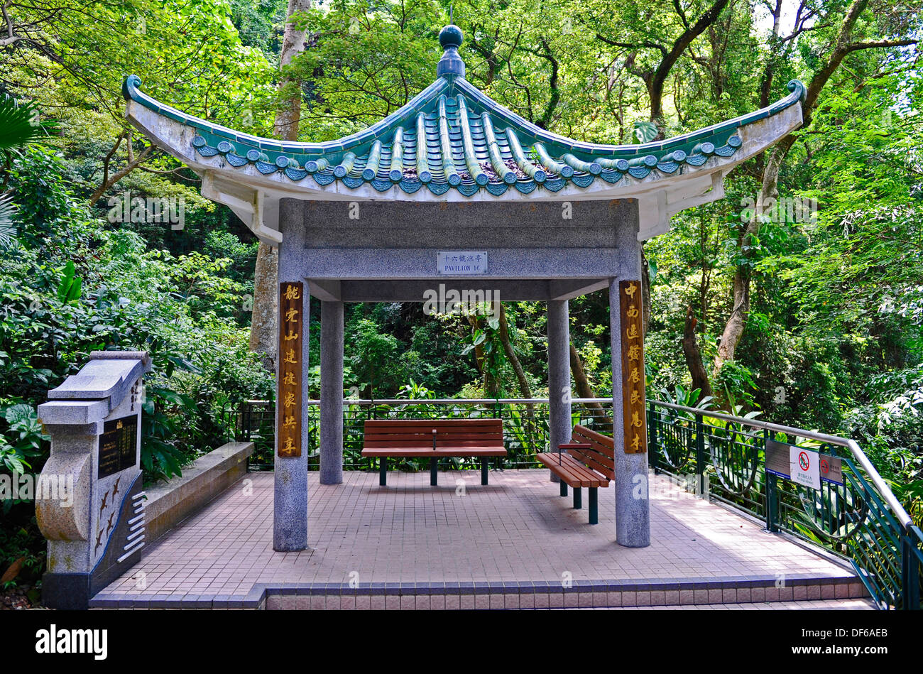 Petit pavillon de style pagode en pierre offrant de l'ombre, un abri et un coin dans un parc de la ville de Hong Kong. Banque D'Images