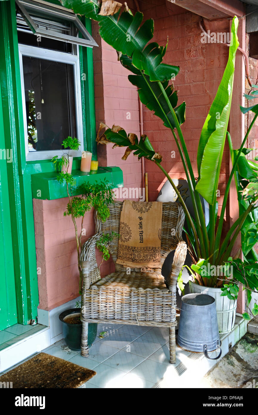Petite maison en briques avec une porte verte et président de canne Banque D'Images
