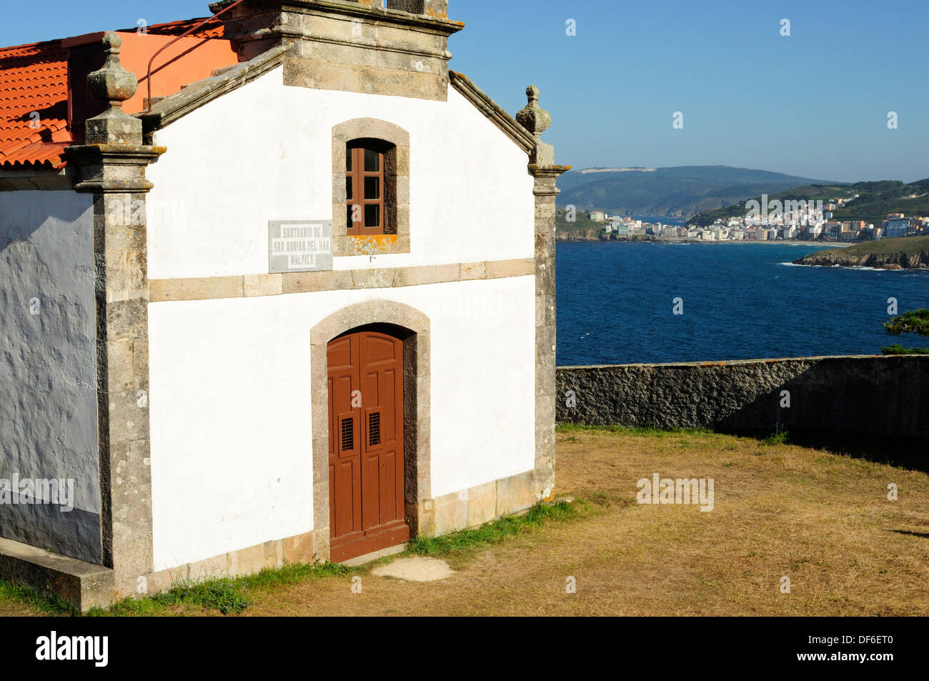 Hadrien San chapelle et le village de Malpica de Bergantiños sur l'arrière-plan, Galice, Espagne. Banque D'Images