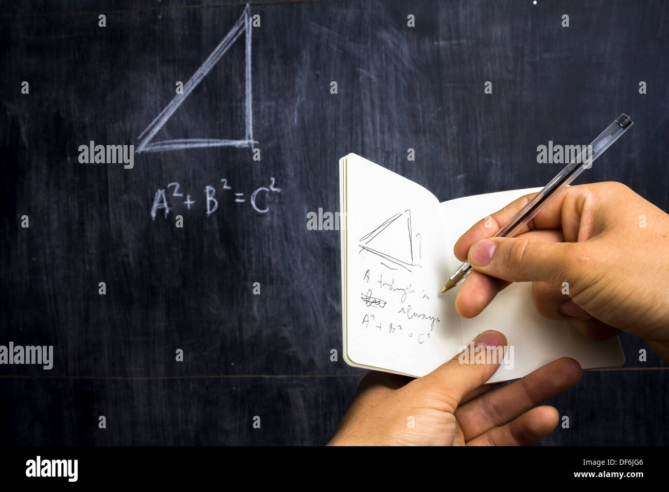 Jeune homme prend des notes du théorème de Pythagore par blackboard Banque D'Images