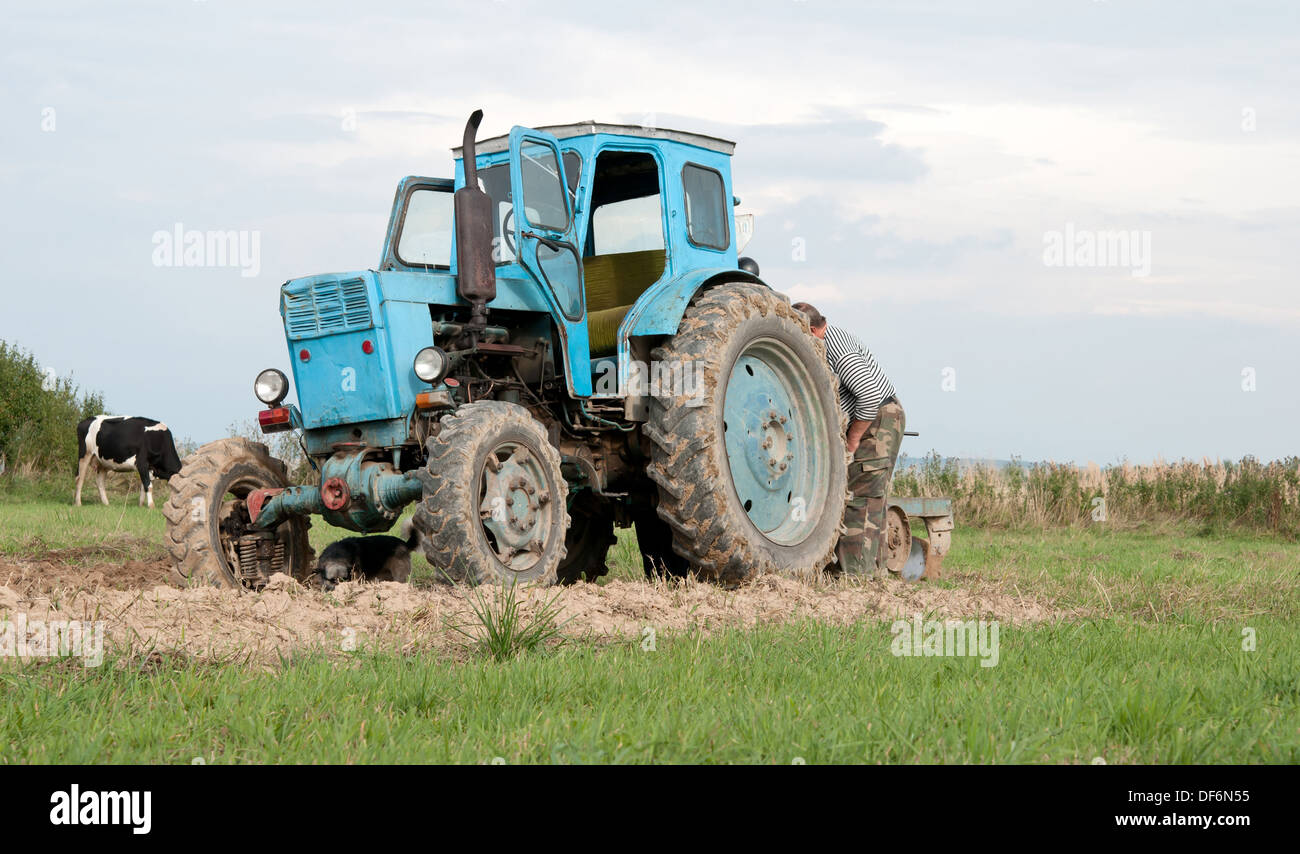 Vieux tracteur bleu en automne sur terrain Banque D'Images