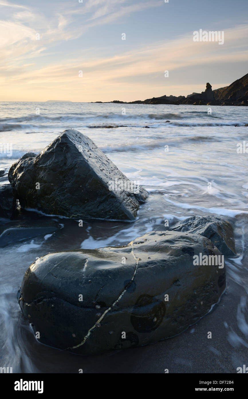 Rochers lisses d'être entraînés par la marée montante à Hartland Quay Beach, North Devon, UK. Banque D'Images