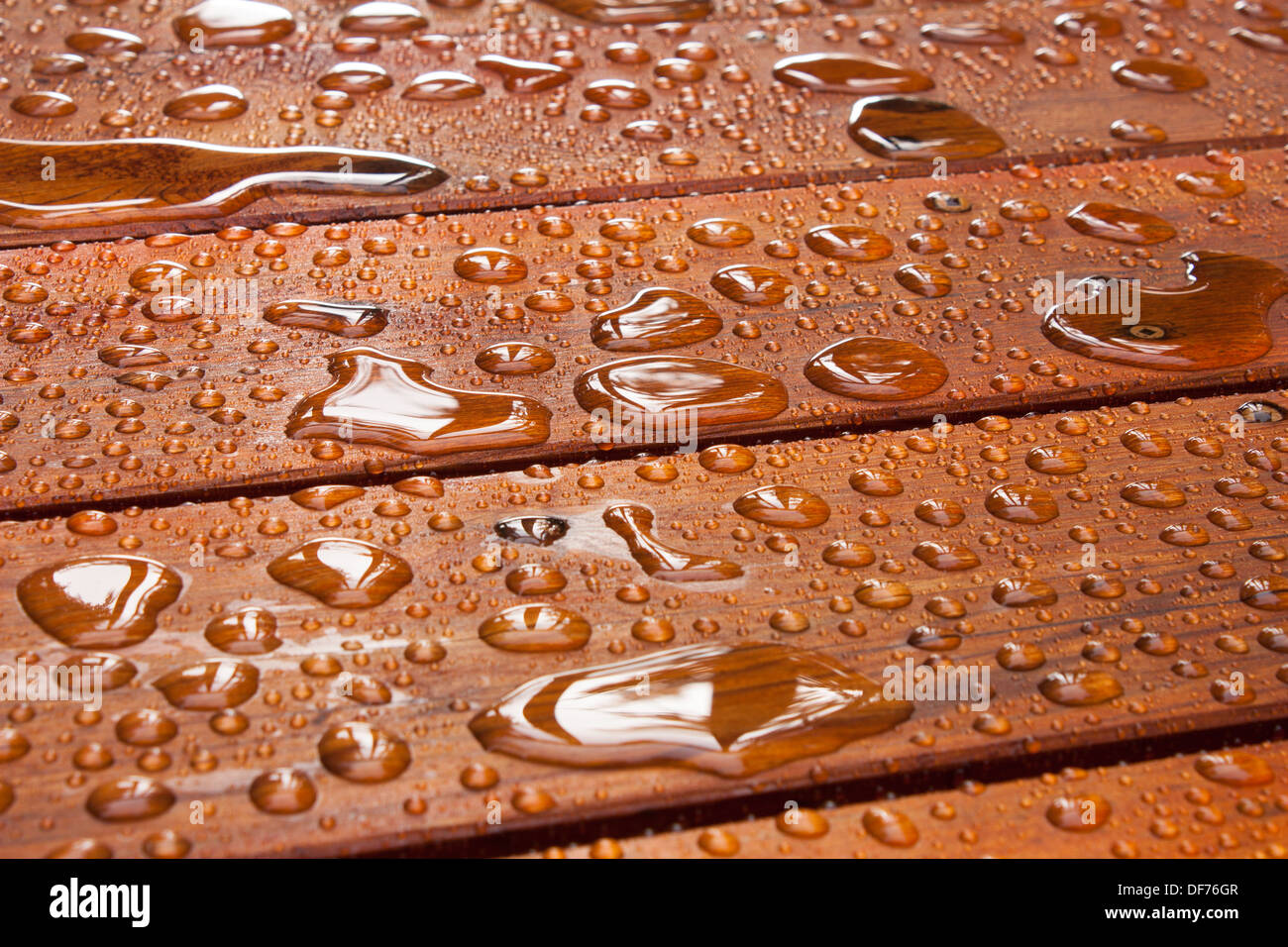 L'eau coule et se flaque, sur un pont récemment taché, après une pluie d'été au cottage Banque D'Images