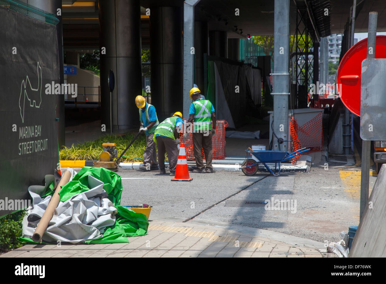 Les travailleurs de la construction, rue de Singapour Asie trois cours works réparer les dommages de l'équipement vert rouge faire transporter de cône Banque D'Images