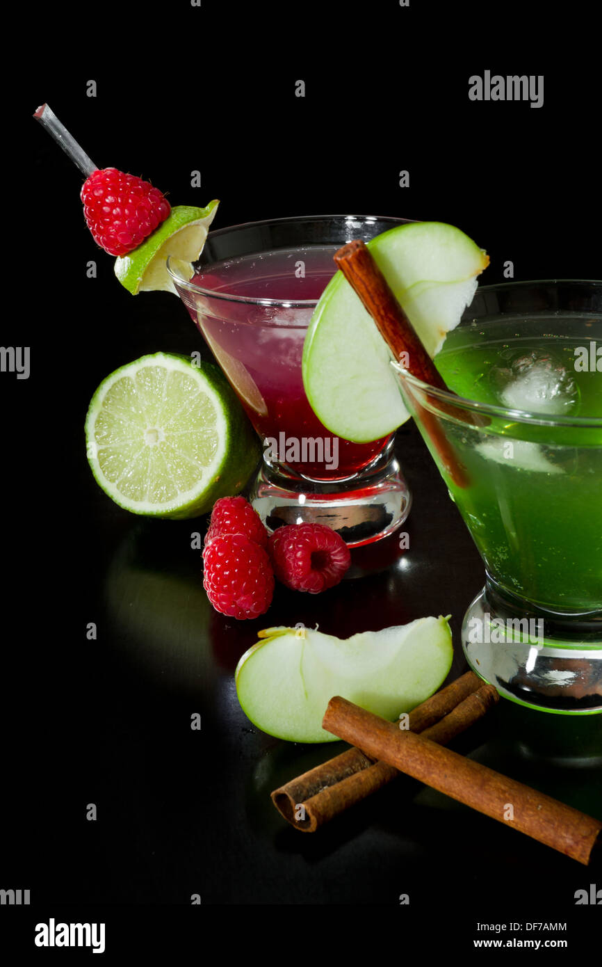 Cocktails d'automne rafraîchissant garni de fruits frais isolé sur un fond noir Banque D'Images