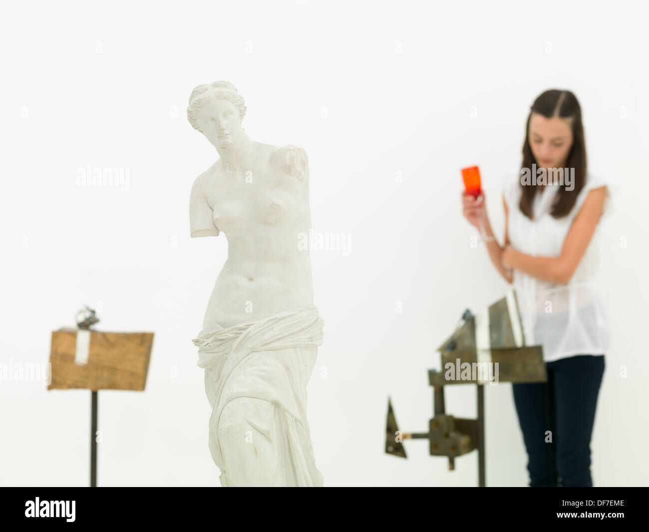 Young caucasian woman standing et d'analyser une oeuvre derrière une réplique de la Vénus de Milo dans un musée Banque D'Images