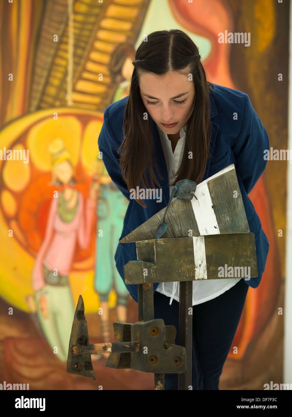 Vue avant du young caucasian woman leaning pour analyser une œuvre d'art, en étroite collaboration avec coloful sur fond de peinture Banque D'Images