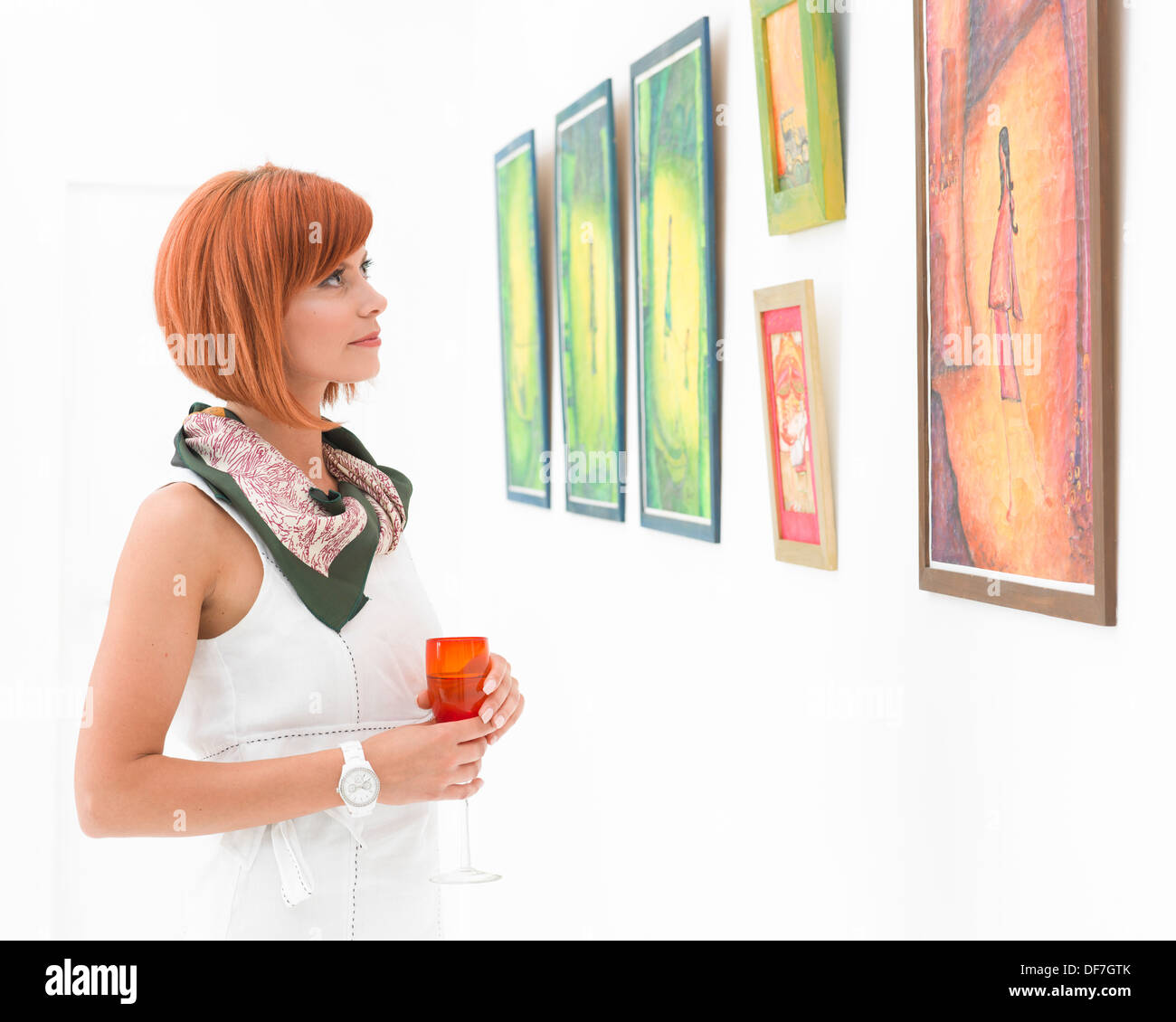 Young caucasian redhead woman standing in a museum admirant tableaux colorés Banque D'Images