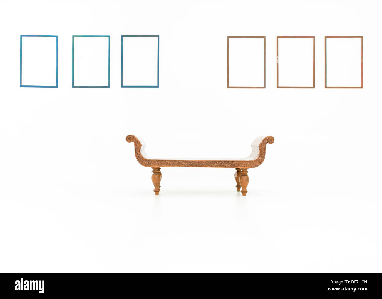 Banc en bois placés dans une pièce blanche vide en face d'images affichées sur les murs Banque D'Images