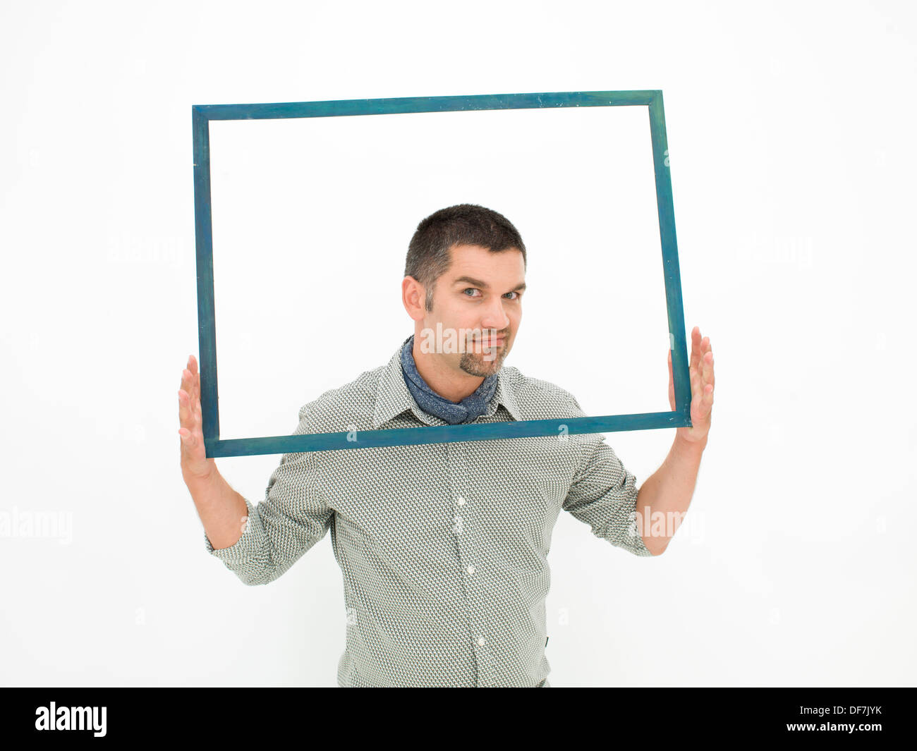 Homme tenant un cadre vide avec l'expression du visage grincheux, sur fond blanc Banque D'Images