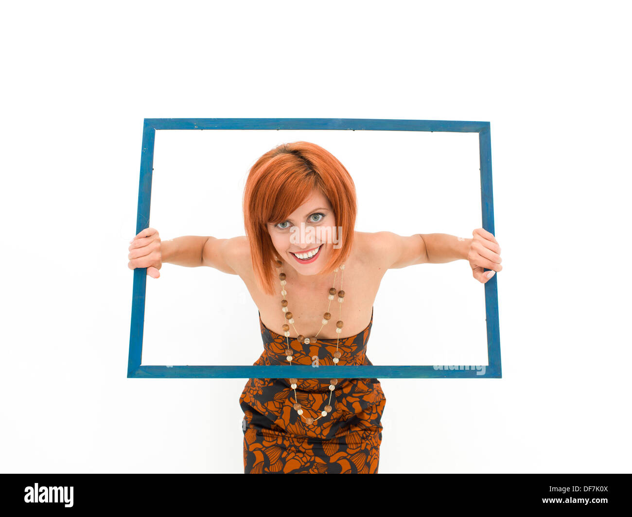 Caucasian woman laughing et sortir d'un cadre vide sur fond blanc Banque D'Images