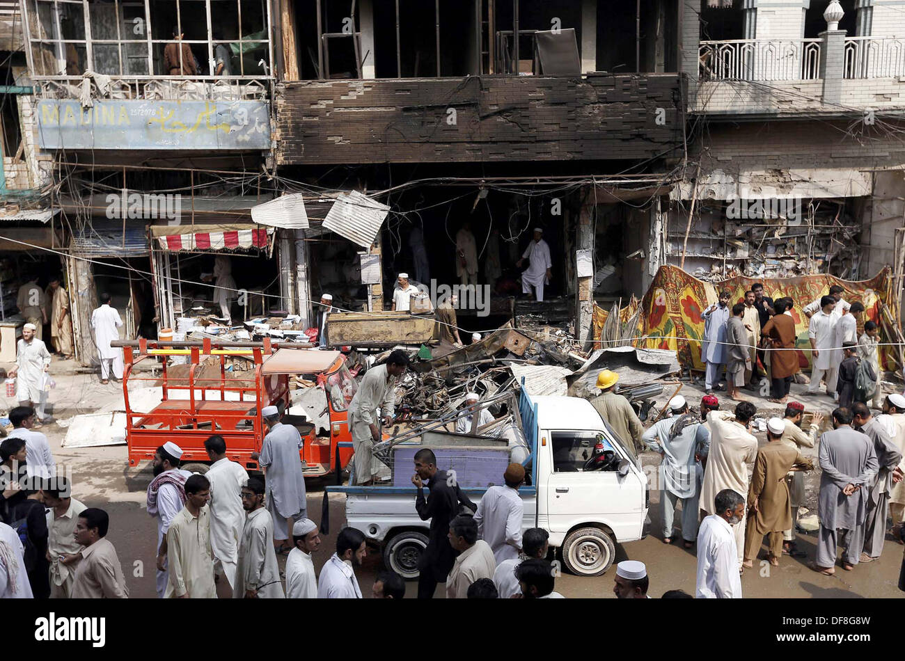 Les gens et les fonctionnaires occupés sauve dans un sauvetage sur le site de l'explosion d'une bombe hier au poste de police de Raziq Khan Qissa Khawani Zone Bazar de Peshawar le lundi, 29 septembre 2013. Au moins 37 personnes ont été tuées et plus de 80 blessés dans une explosion près de Khan Raziq de police de Qissa Khawani bazar de Peshawar. Plusieurs véhicules et bâtiments adjacents ont été endommagés. Les forces de l'ordre ont encerclé la zone. Banque D'Images