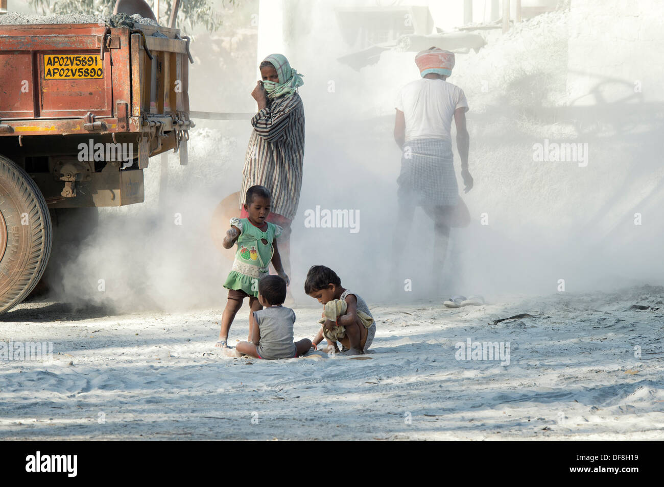 Les enfants indiens jouant, entouré par la poussière, sans protection, à l'écrasement fonctionne. L'Andhra Pradesh, Inde Banque D'Images