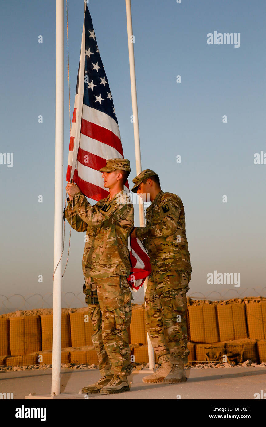 Tarin Kot, en Afghanistan. 29 août, 2013. Ccp de l'armée des États-Unis. Michael Arsenault et Jesus Arias abaisser les drapeaux du Camp Hollande mémorial pour la dernière fois le 29 septembre 2013 à Tarin Kot, en Afghanistan. Comme les forces américaines continuent d'attirer les forces canadiennes en Afghanistan le camp sera remis aux forces afghanes. © Planetpix/Alamy Live News Banque D'Images