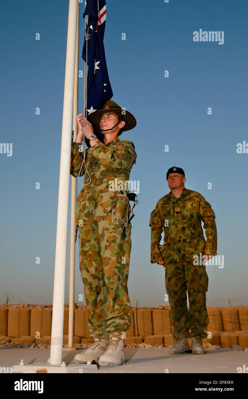 Tarin Kot, en Afghanistan. 29 août, 2013. Royal Australian Air Force richesses Jennine Adjudant et le Sgt. Chris Cambell descendre le drapeau australien au cours d'une cérémonie du drapeau le plus bas du Camp Hollande mémorial pour la dernière fois le 29 septembre 2013 à Tarin Kot, en Afghanistan. Comme les forces de la FIAS continuent à tirer vers le bas en Afghanistan le camp sera remis aux forces afghanes. © Planetpix/Alamy Live News Banque D'Images