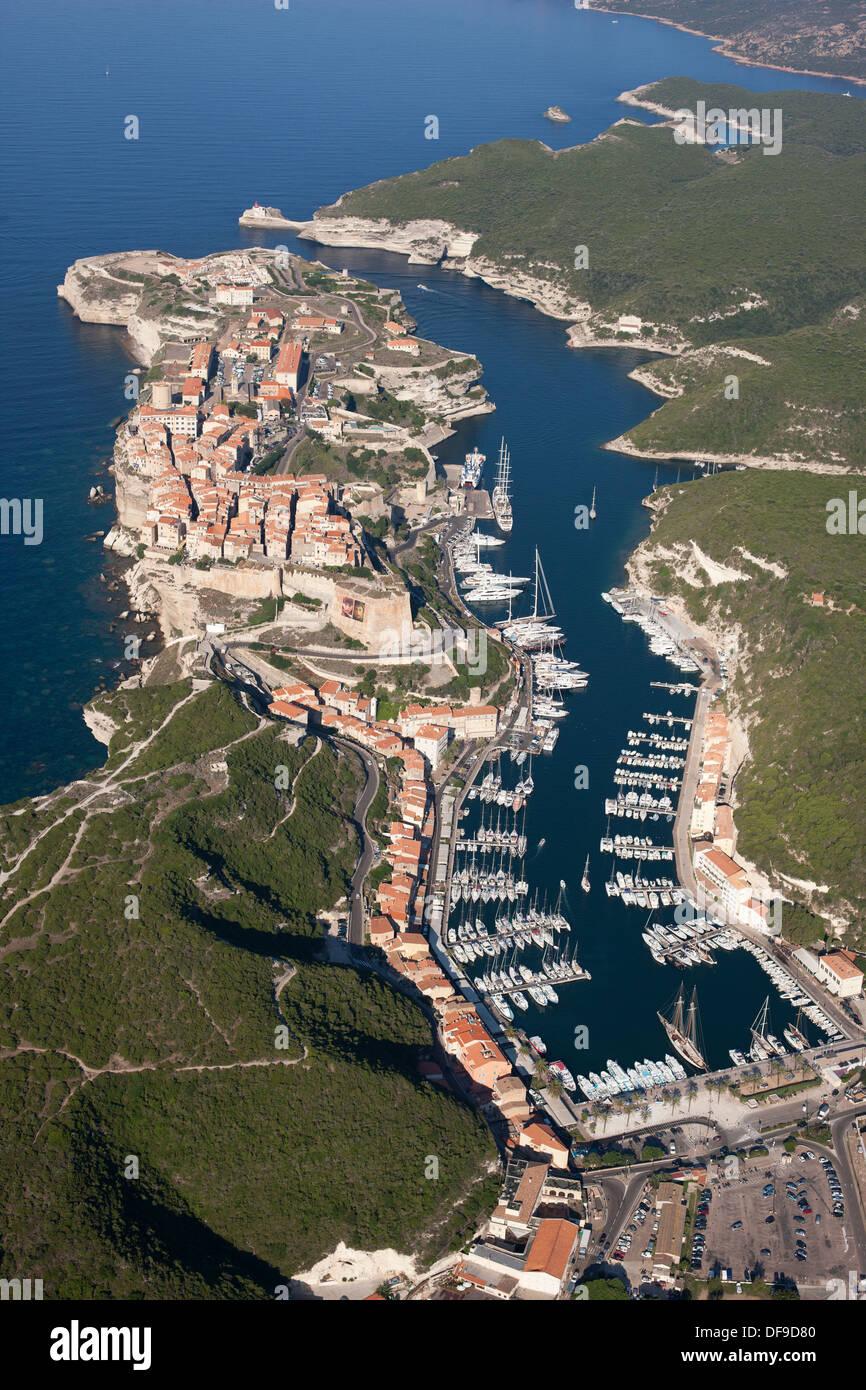 VUE AÉRIENNE.Ville médiévale pittoresque perchée sur une falaise entre la mer Méditerranée et un point d'entrée avec une marina.Bonifacio, Corse, France. Banque D'Images