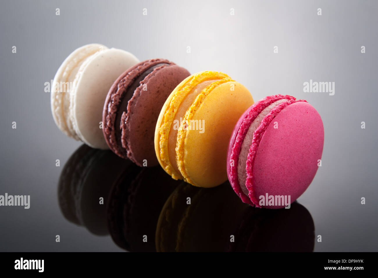 Délicieux macarons de différentes saveurs et couleurs sur gradient background Banque D'Images