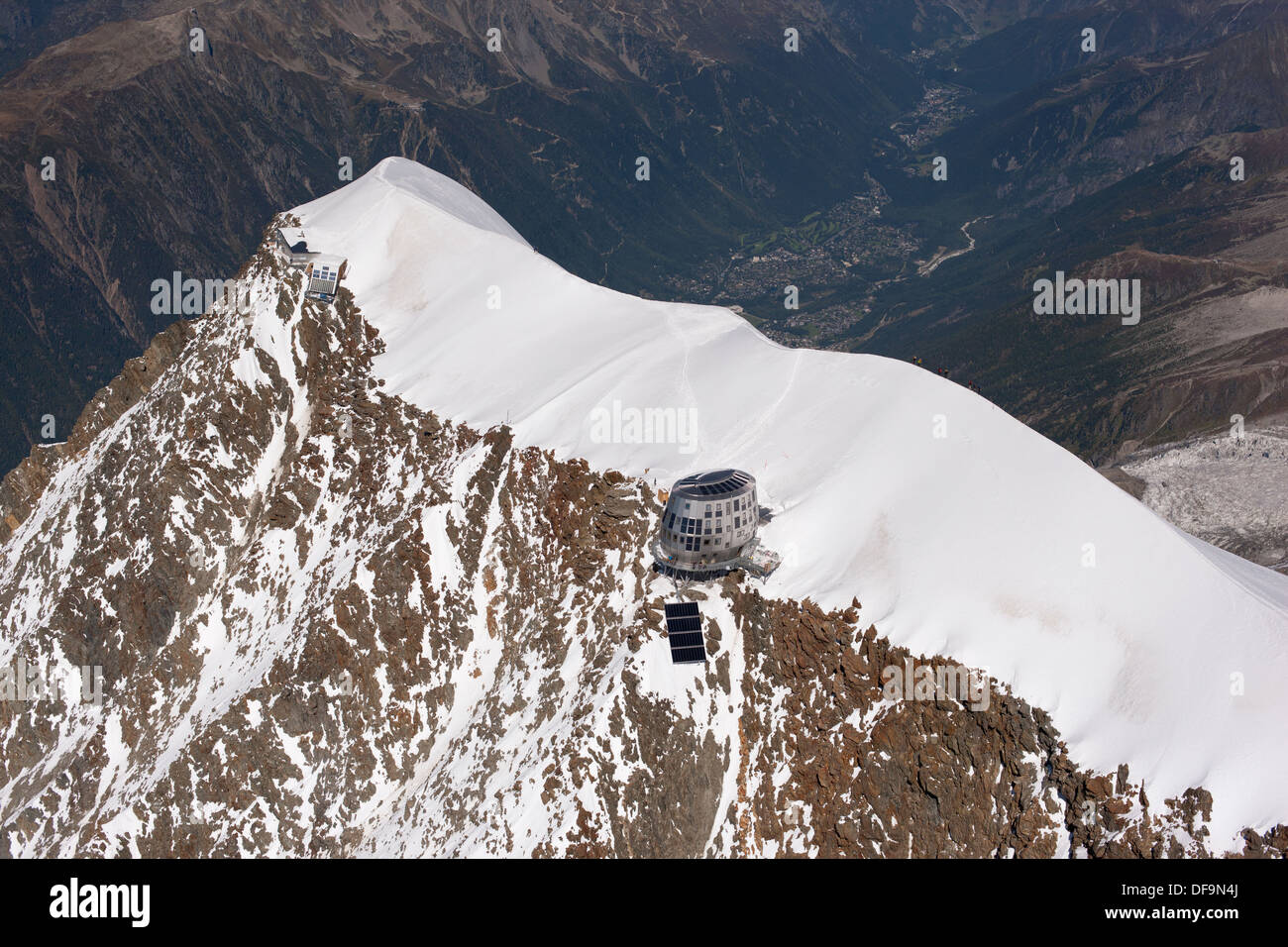 VUE AÉRIENNE.Sommet de l'aiguille du Goûter (altitude: 3863m) avec la nouvelle cabane de montagne futuriste.Chamonix (altitude: 1035m) au loin.France. Banque D'Images