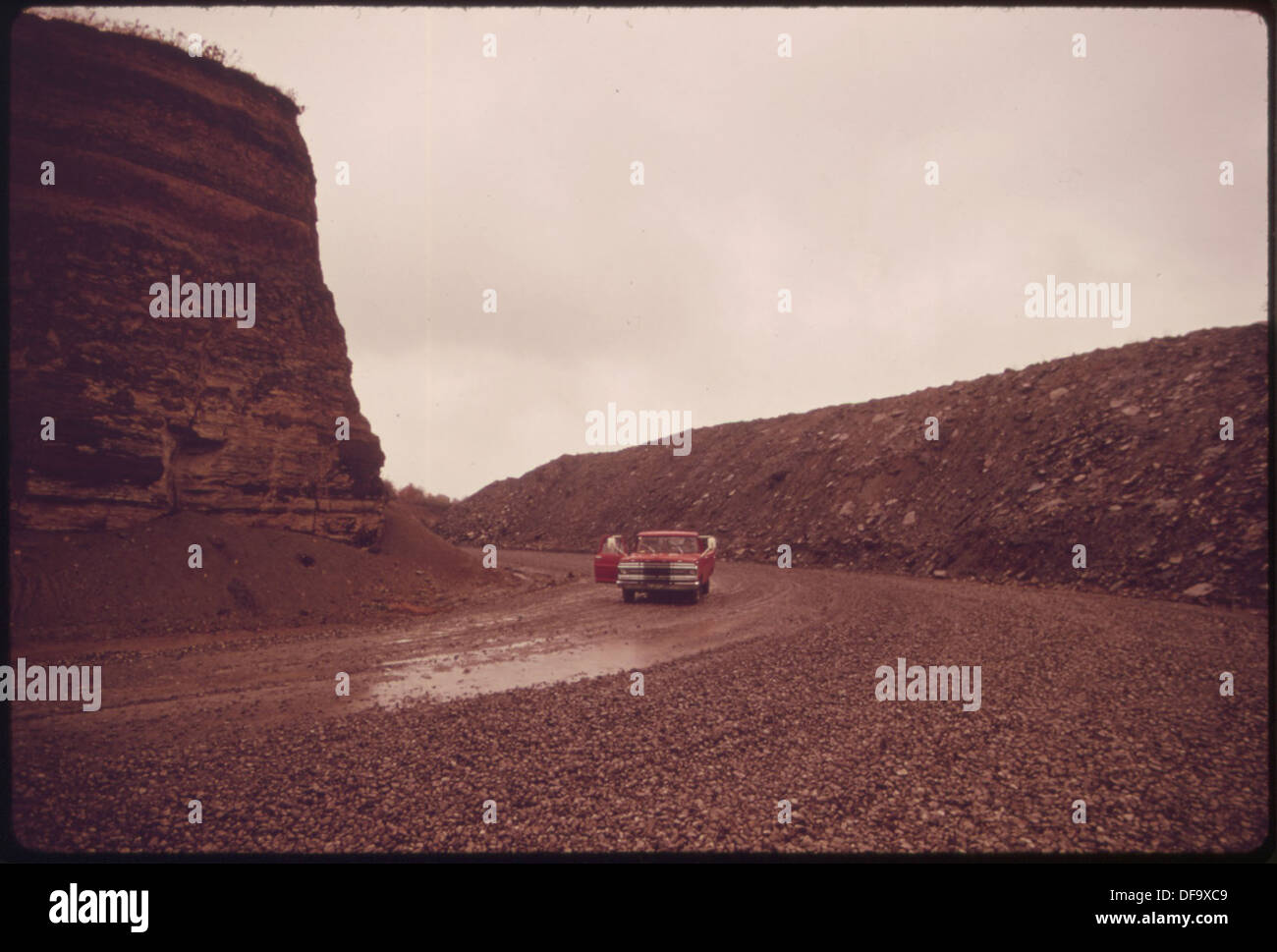 Route de gravier utilisée pour transporter du charbon à partir d'une pelle minière, avec une paroi haute visible sur le côté droit, résultant des opérations minières. Banque D'Images