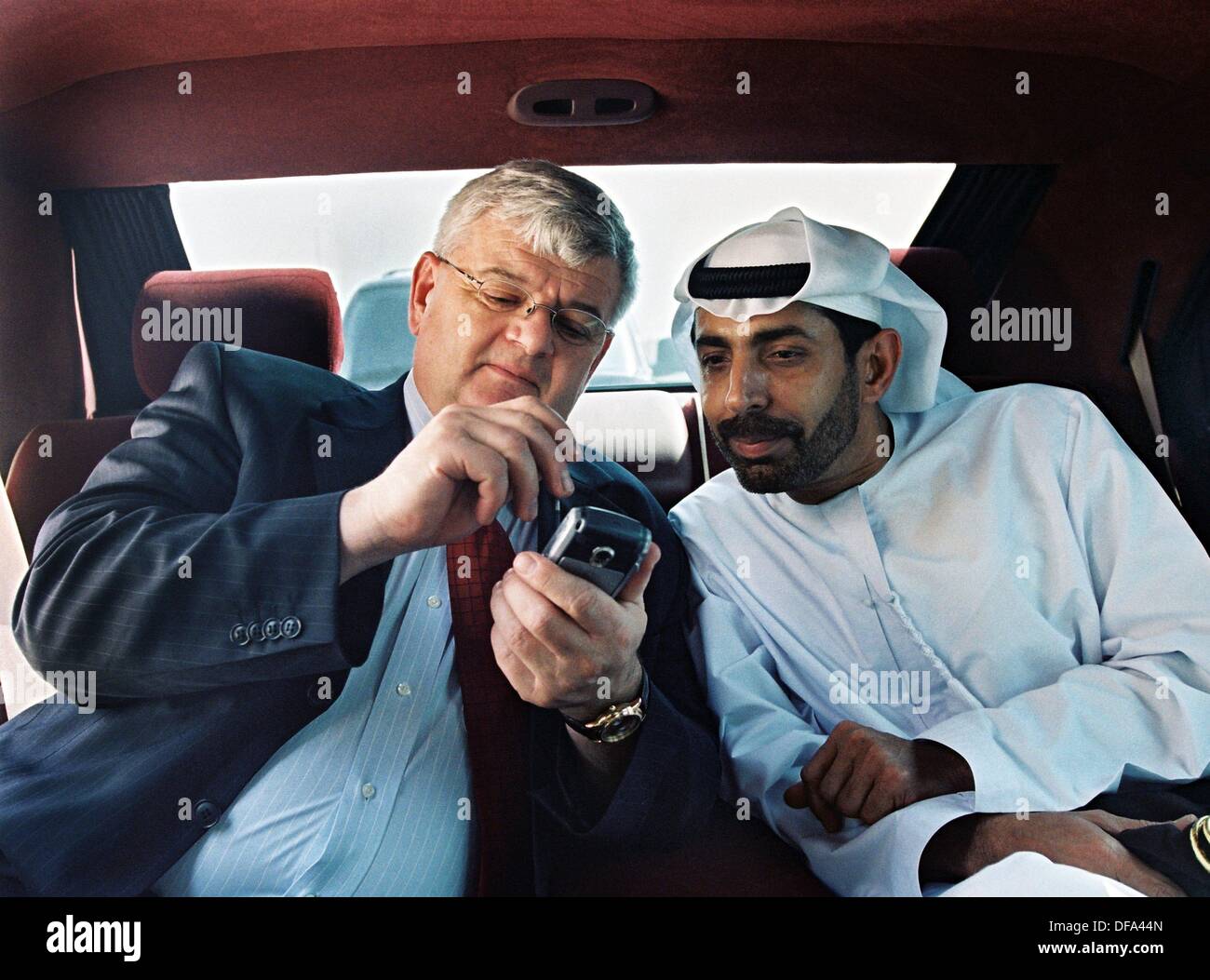 Le ministre allemand des affaires étrangères Joschka Fischer parle à Abdullah Rashid Al Nuaimi sur les fonctions de son téléphone mobile pendant son voyage à travers les pays arabes le 21 juin en 2004. Banque D'Images