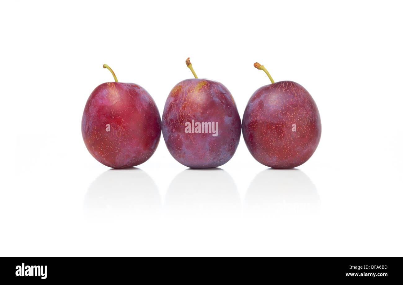 Ensemble et la moitié des prunes sur un fond blanc. Banque D'Images