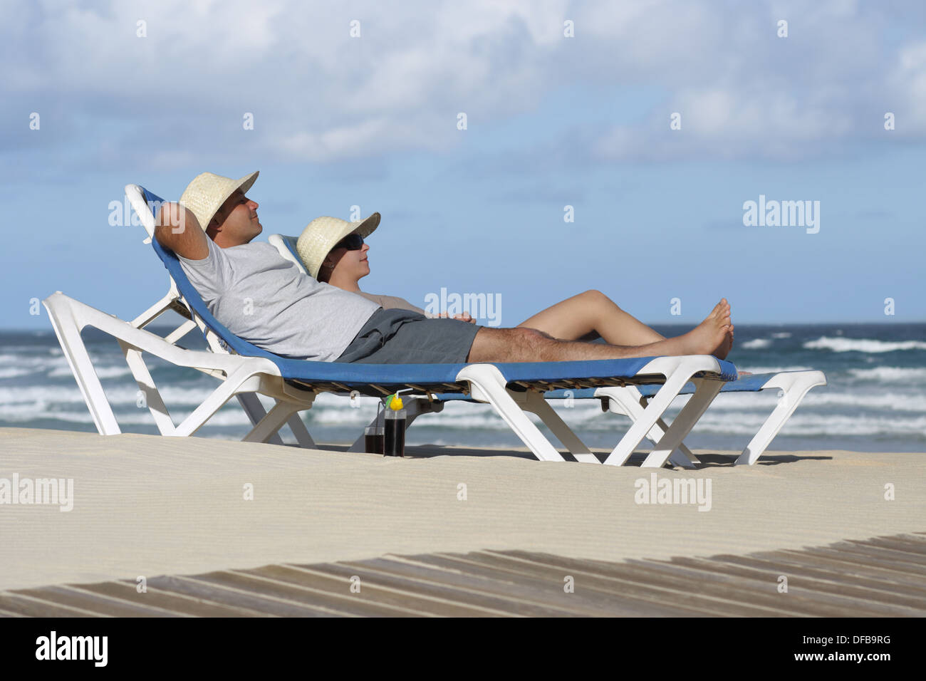 Couple de soleil et plage chaise chaise longue Banque D'Images