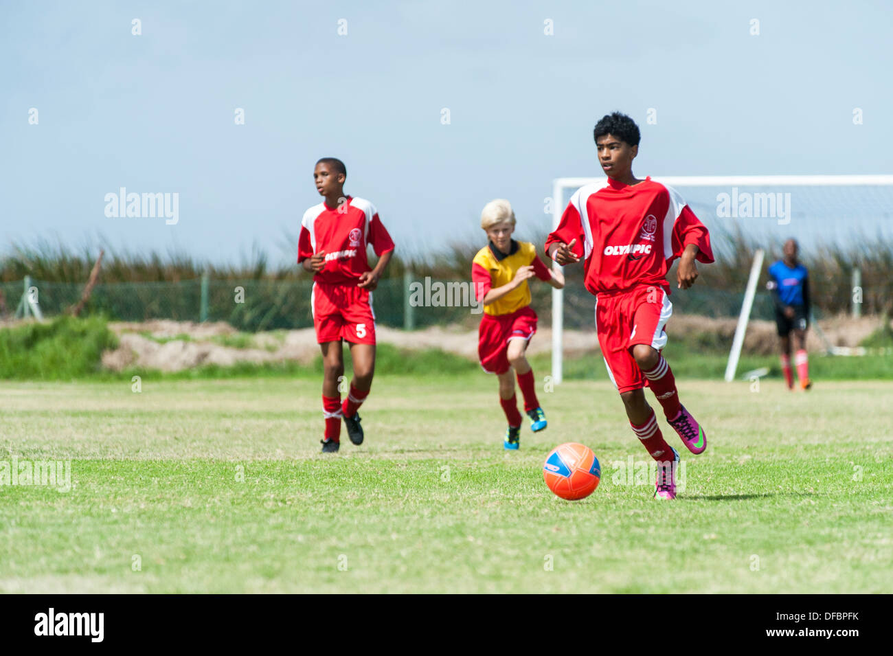 Joueurs de football junior exécutant avec la balle, Le Cap, Afrique du Sud Banque D'Images