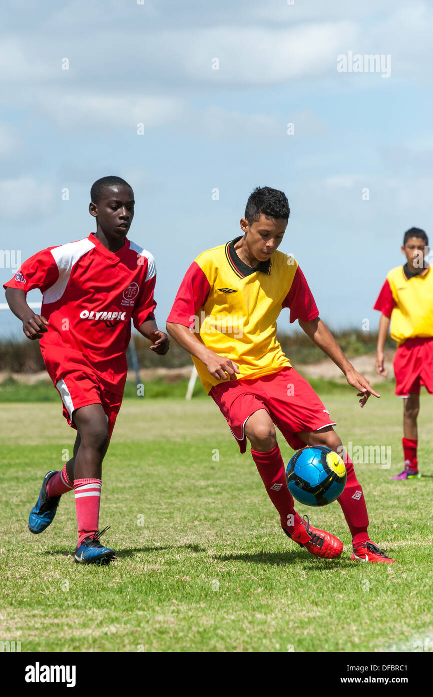 Un joueur de football junior la protection de la balle, Le Cap, Afrique du Sud Banque D'Images