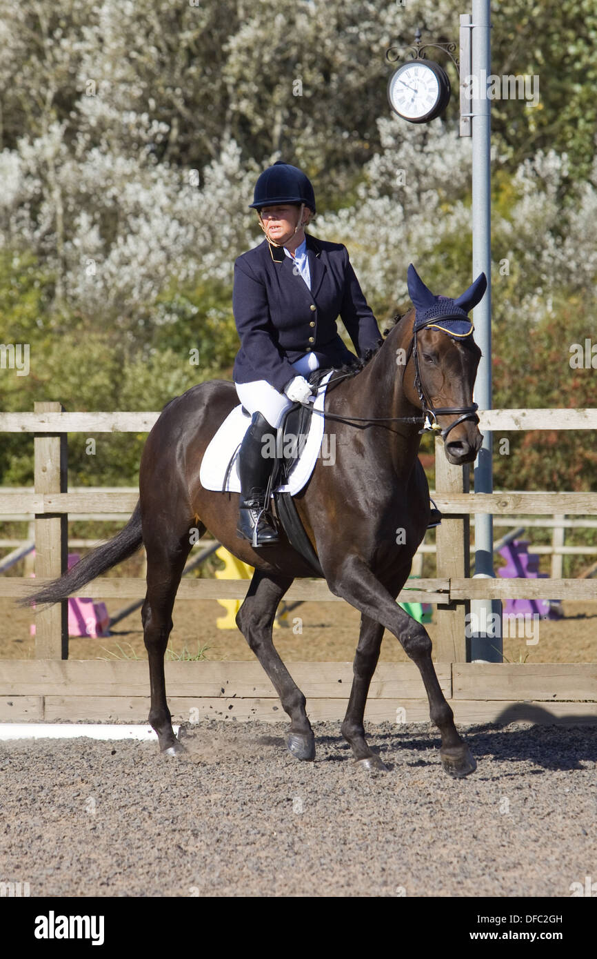 Un cheval et cavalier en compétition dans une épreuve de dressage qui s'est  tenue à l'extérieur, sur un sable et bien sûr en caoutchouc en Angleterre  Photo Stock - Alamy