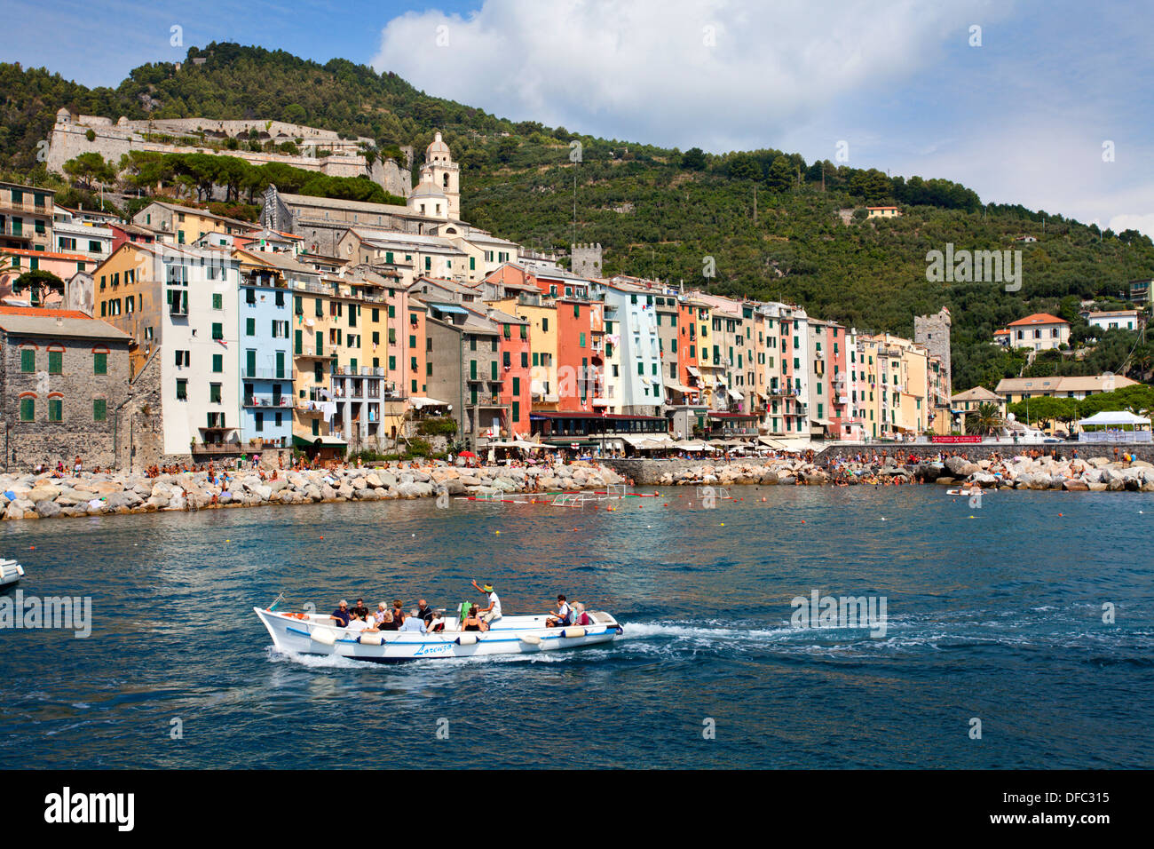 Voile en passant le bord peint de couleurs vives, les maisons à Porto Venere Ligurie Italie Banque D'Images