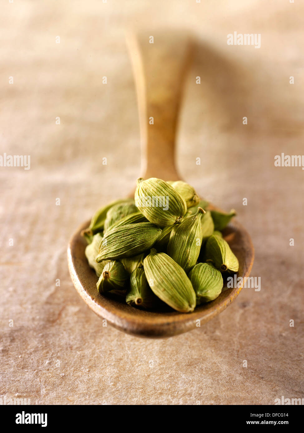 Cardamome verte une seedsin cuillère en bois contre un arrangement composé de fond naturel Banque D'Images