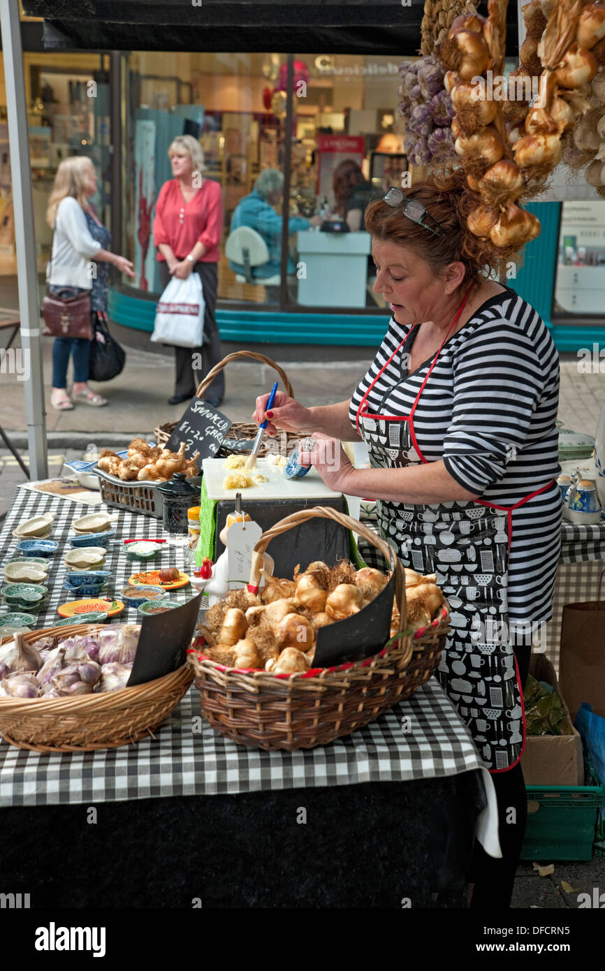 Femme vendant de l'ail sur un stand aux Agriculteurs Market Parliament Street York North Yorkshire Angleterre Royaume-Uni GB Grande-Bretagne Banque D'Images