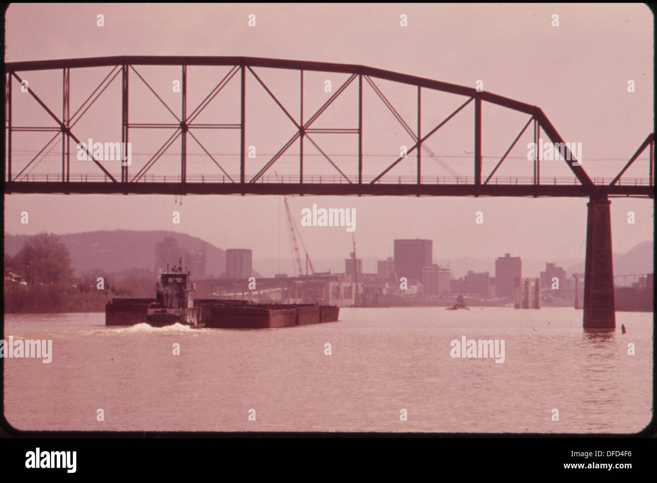 Des barges de charbon vides passent sous un pont ferroviaire sur la rivière Kanawha, illustrant le transport de matériaux dans l'économie industrielle de la région. Banque D'Images