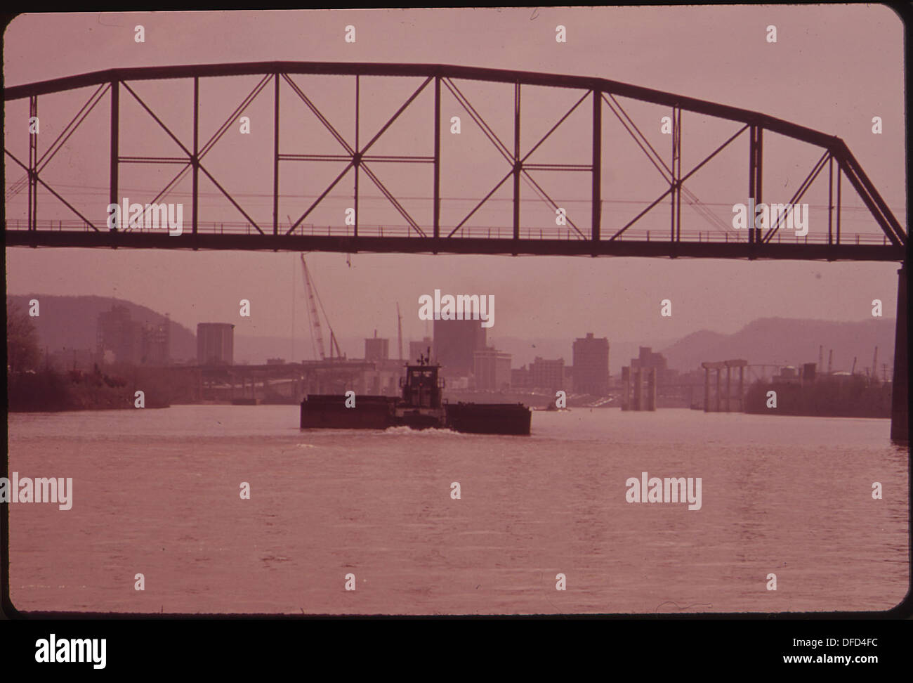 Des barges de charbon vides flottent sur la rivière Kanawha, passant sous un pont ferroviaire, reflétant le transport de marchandises et l'industrie régionale dans la région. Banque D'Images