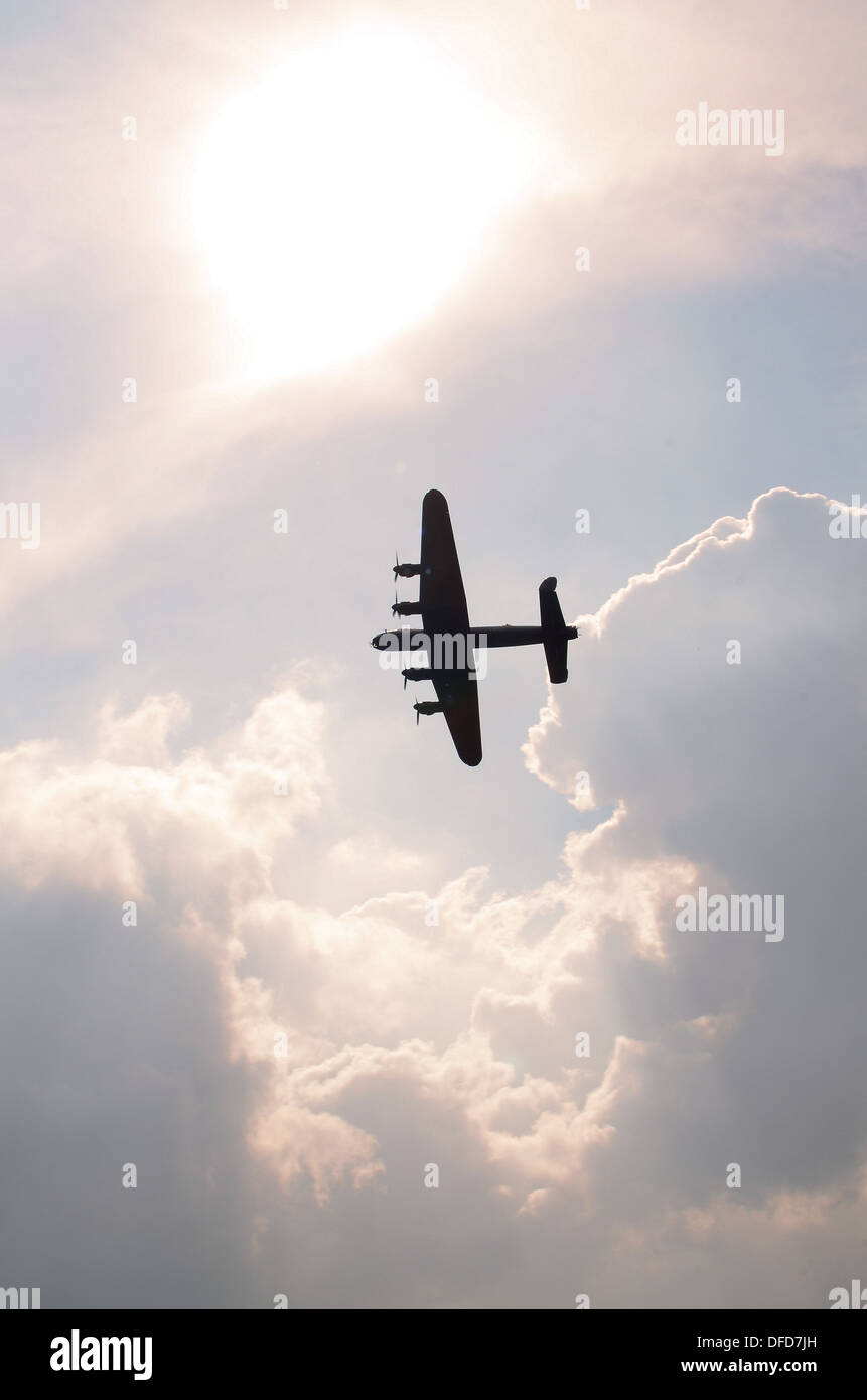 Avro Lancaster de la Royal Air Force Battle of Britain Memorial Flight vole dans un ciel sombre contre le soleil. Concept divin Banque D'Images
