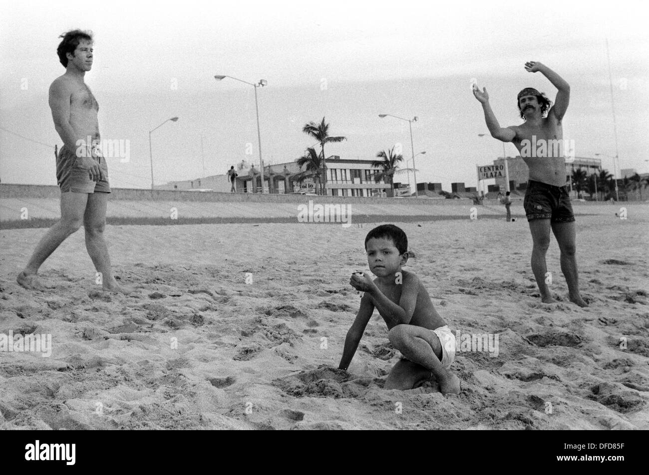 Mazatlan Mexique 1973 touristes américains sur la plage, accrochés pendant les vacances de Noël. Le jeune garçon mexicain a un petit oiseau dans la main. Années 1970 État mexicain de Sinaloa. HOMER SYKES Banque D'Images