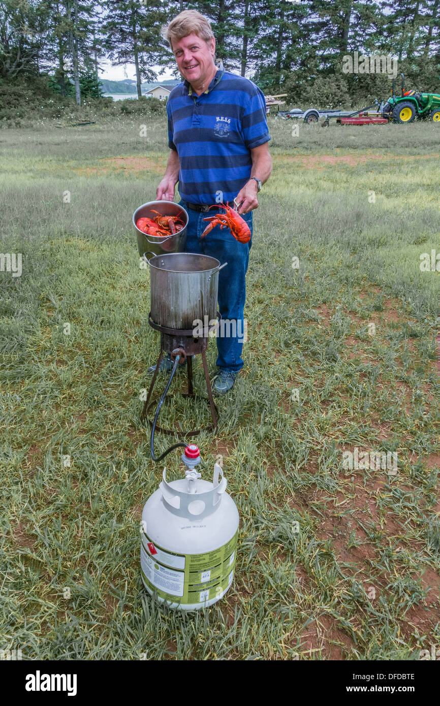 Un Canadien préparer les homards dans un pot d'eau bouillante à l'extérieur, sur l'Île du Prince Édouard, Canada. Banque D'Images