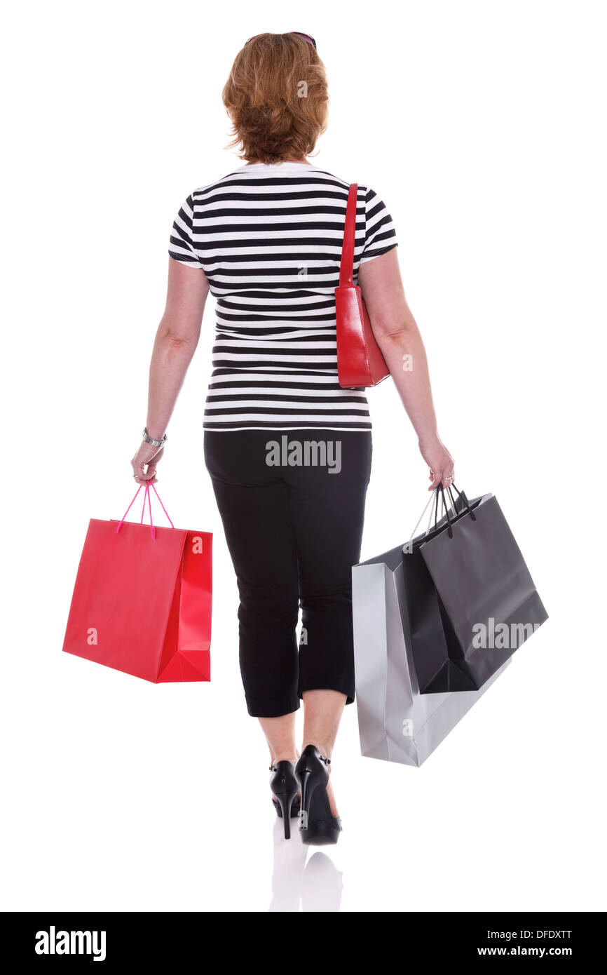 Vue arrière d'un smartly dressed woman carrying shopping bags, isolé sur un fond blanc. Banque D'Images