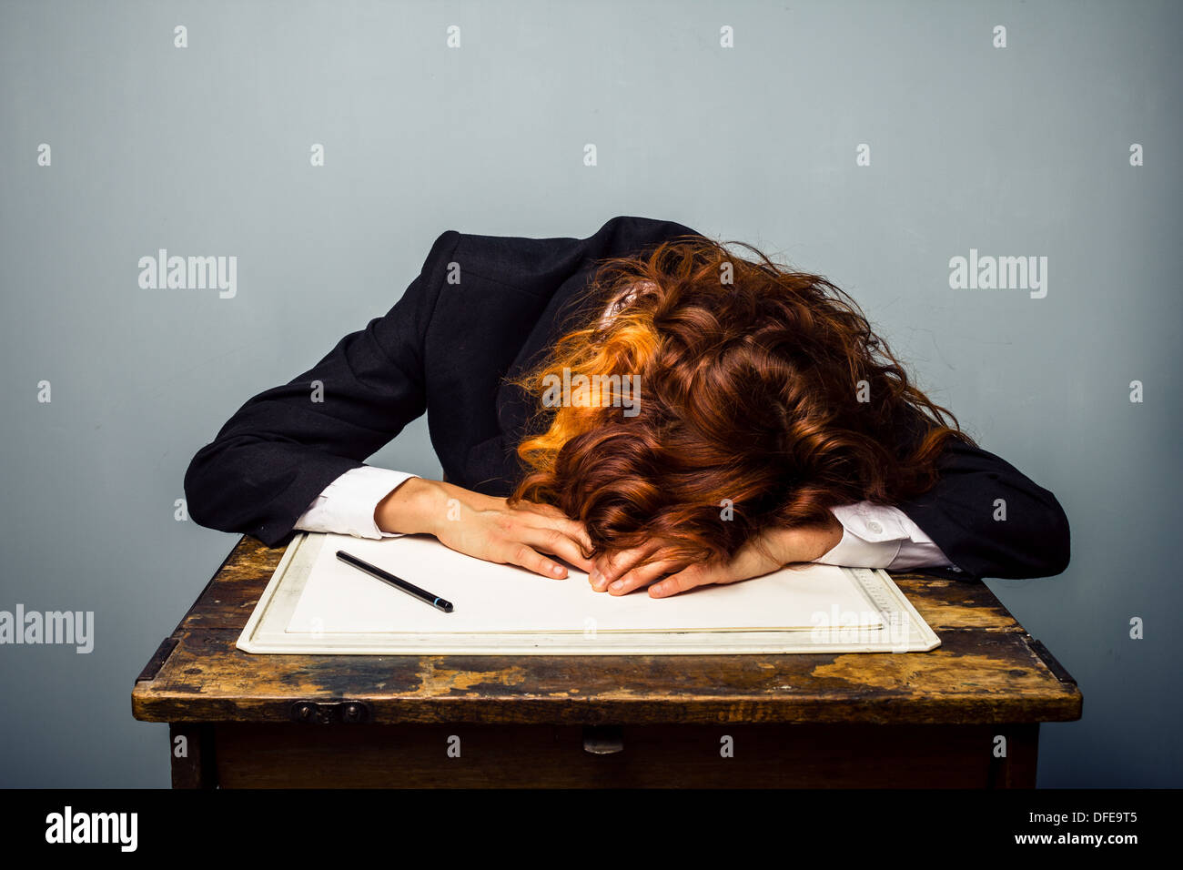Jeune femme d'affaires est endormi à son bureau Banque D'Images