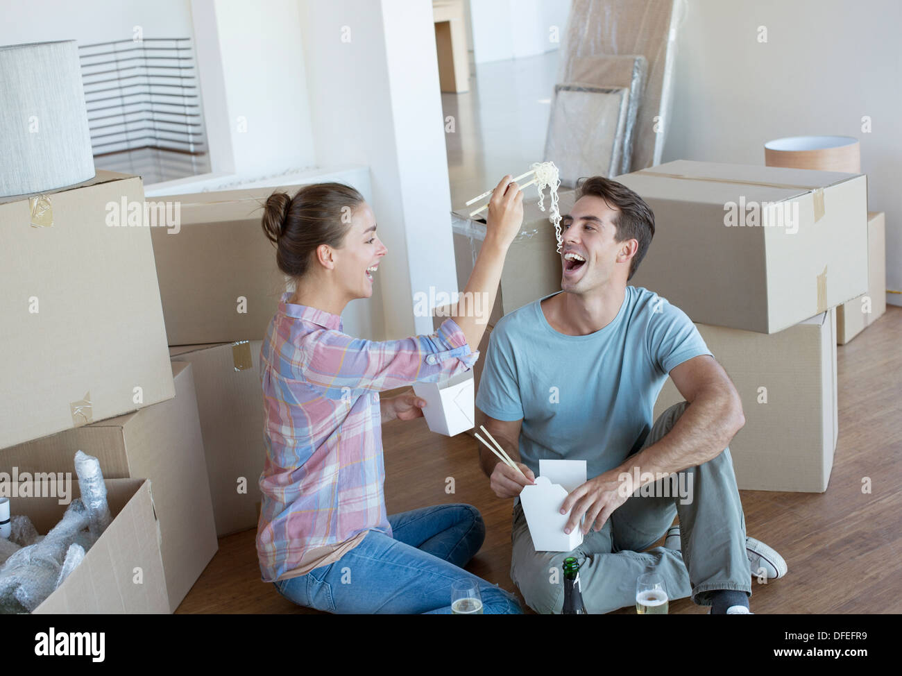 Couple eating Chinese prendre de la nourriture dans la nouvelle maison Banque D'Images