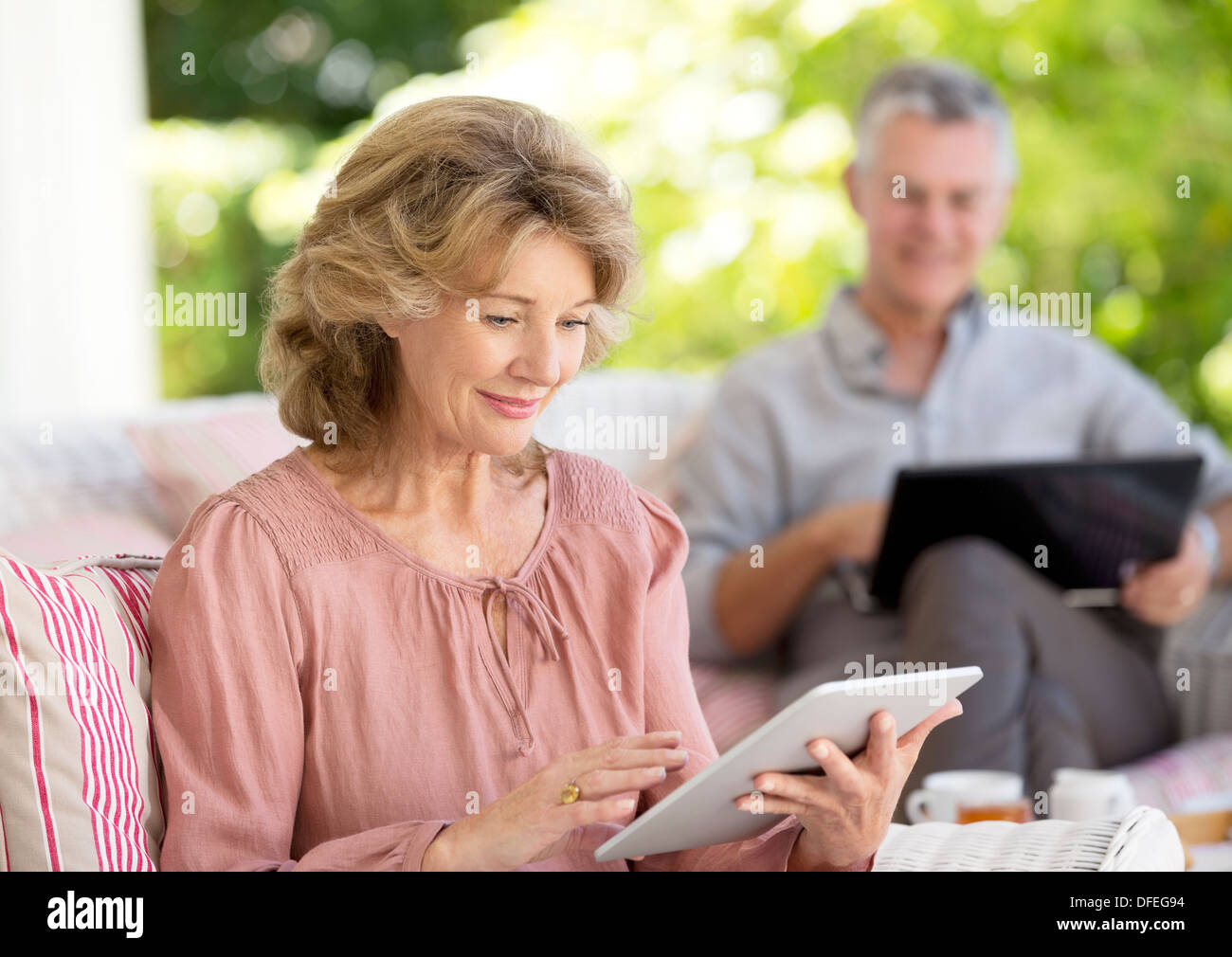 Senior woman using digital tablet on patio Banque D'Images