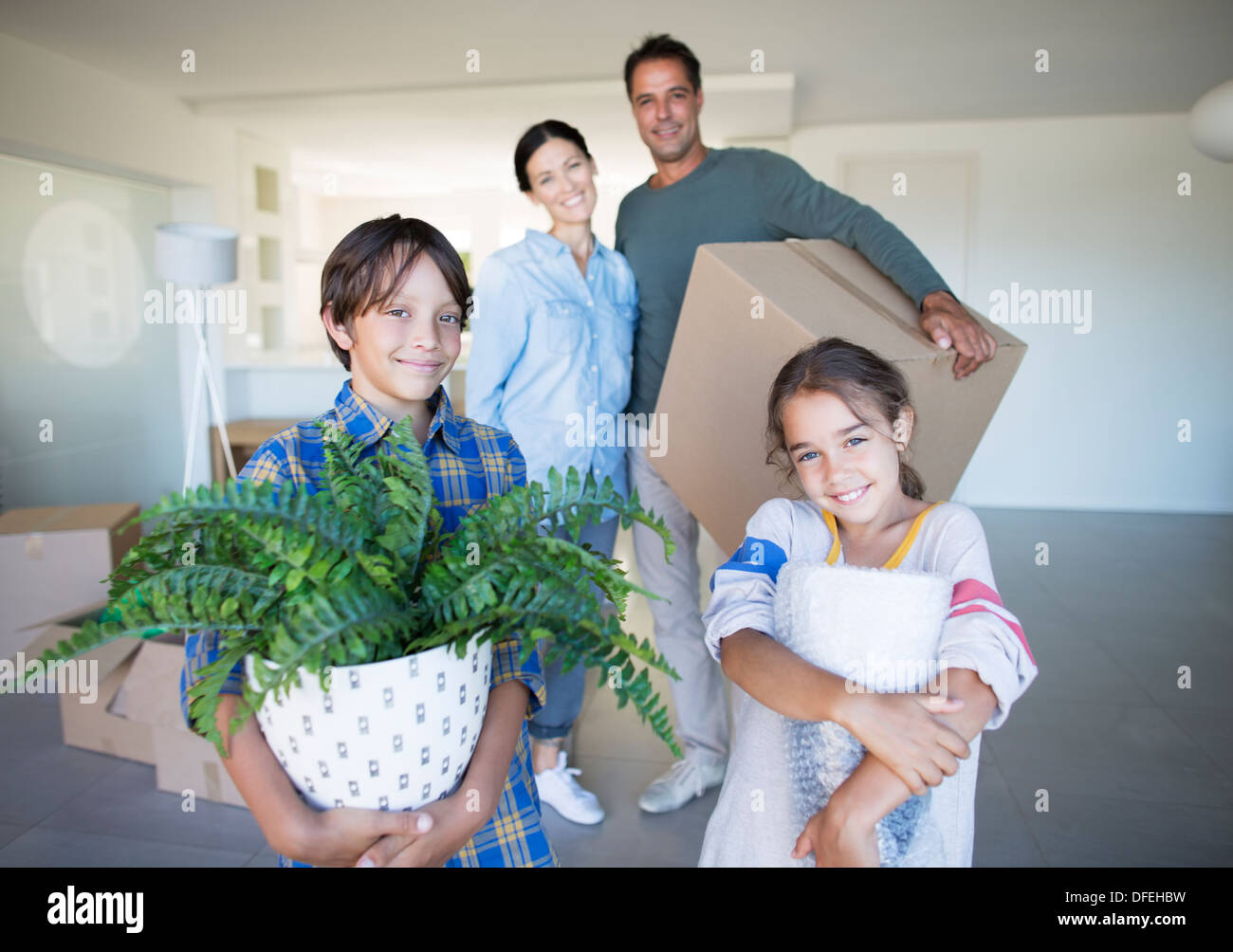 Portrait of smiling family holding possessions dans nouvelle maison Banque D'Images
