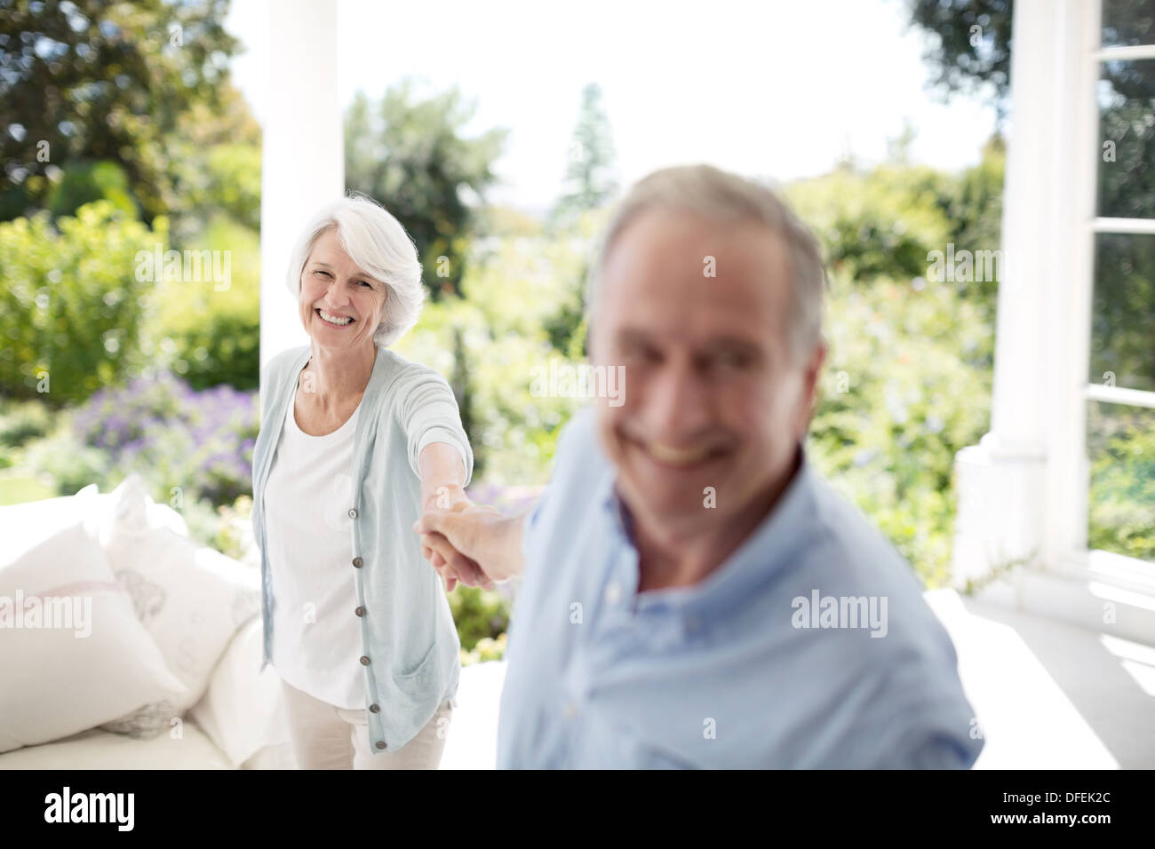 Senior couple holding hands on patio Banque D'Images