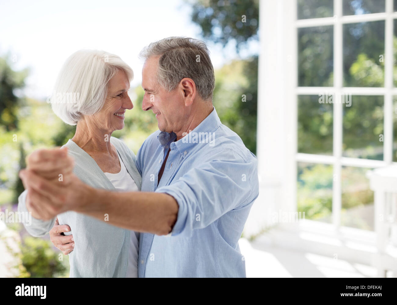 Senior couple dancing on patio Banque D'Images