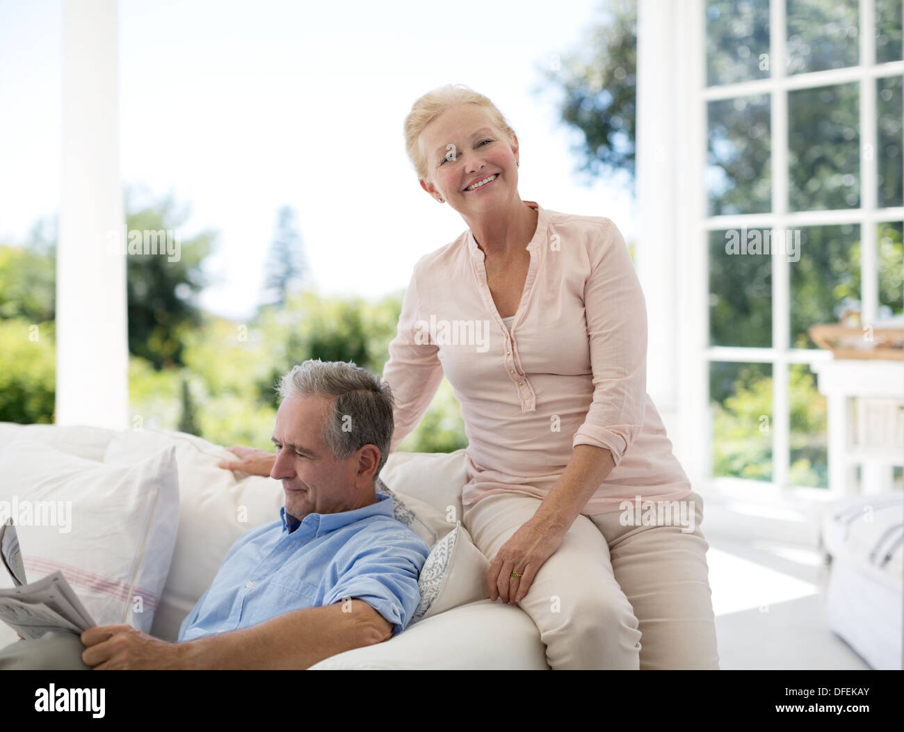 Senior couple relaxing on sofa on porch Banque D'Images