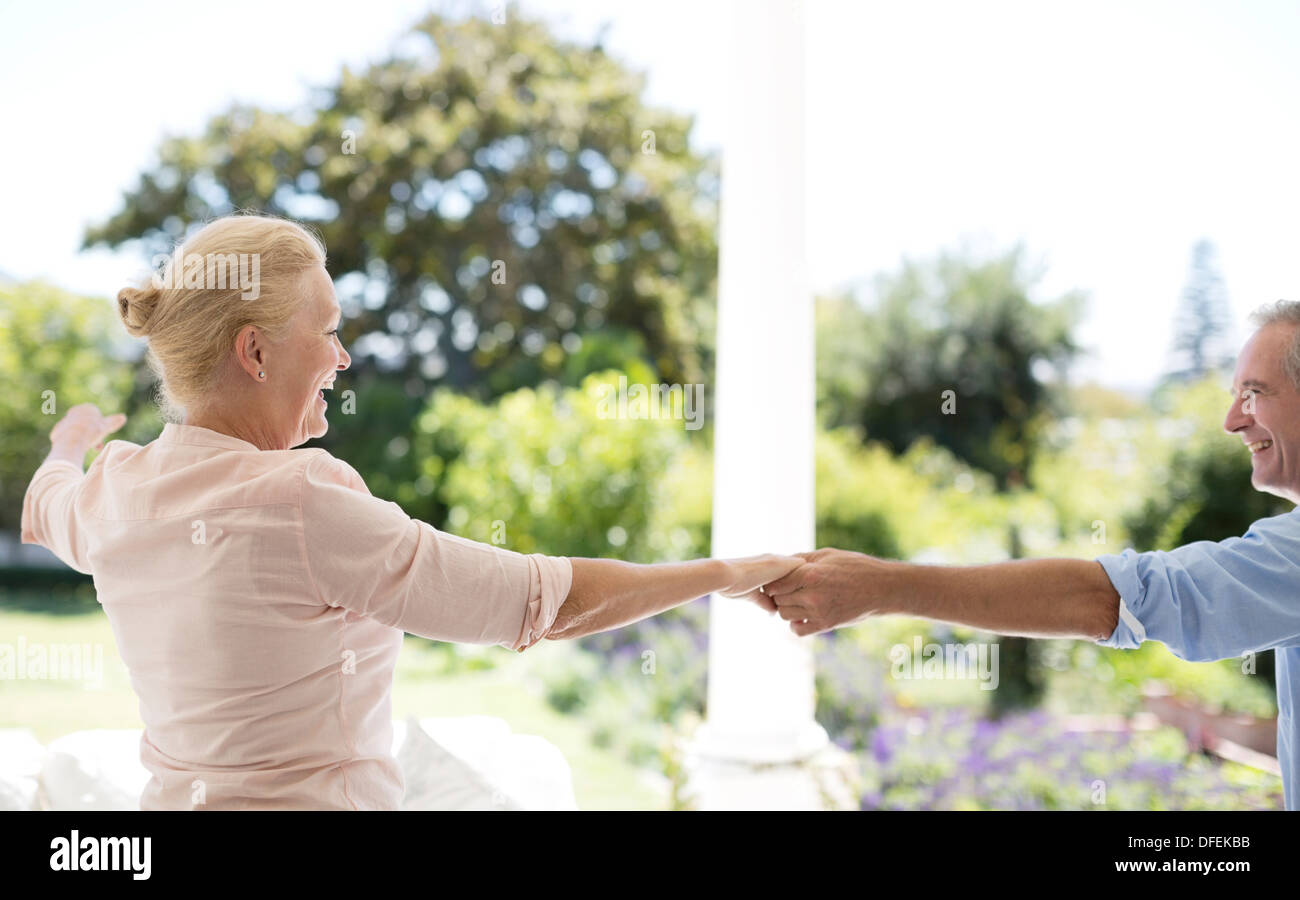 Senior couple dancing on patio Banque D'Images
