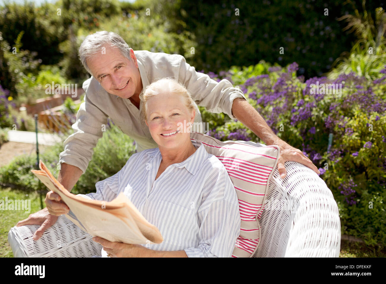 Senior couple reading newspaper in garden Banque D'Images
